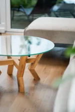 Konferenční dubový stůl Bon Veyra se skleněnou deskou Glase Cir 80 cm v interiéru pohled na detail pravé strany.