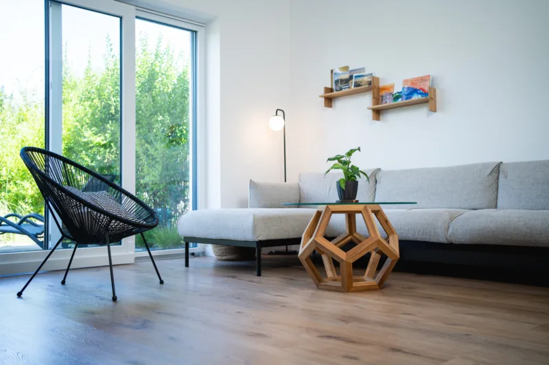 Konferenční stůl Bon Lioro z masivního dubu se skleněnou deskou Glase Cir pohled na celý interiér s rostlinou.