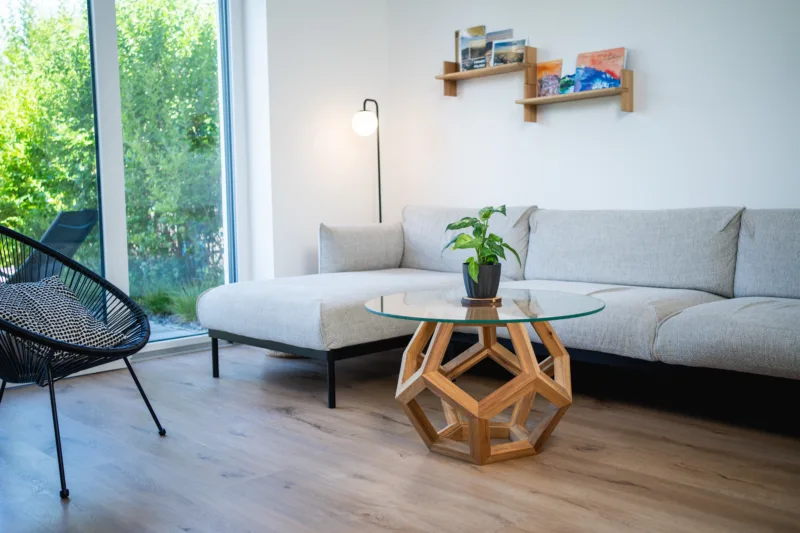 Konferenční stůl Bon Lioro z masivního dubu se skleněnou deskou Glase Cir pohled na celek interiéru.