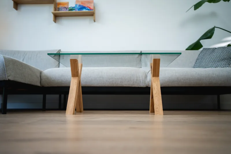 Konferenční stůl z dubového dřeva Bon Ravera se skleněnou deskou Glase Cirte v interiéru pohled zepředu zdola.