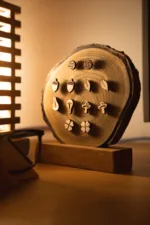 Dřevěný stojan na náušnice Guliver zepředu s lampou.