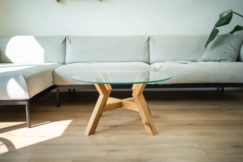 Konferenční dubový stůl Bon Veyron se skleněnou deskou Glase Cir 80 cm v interiéru pohled zepředu.