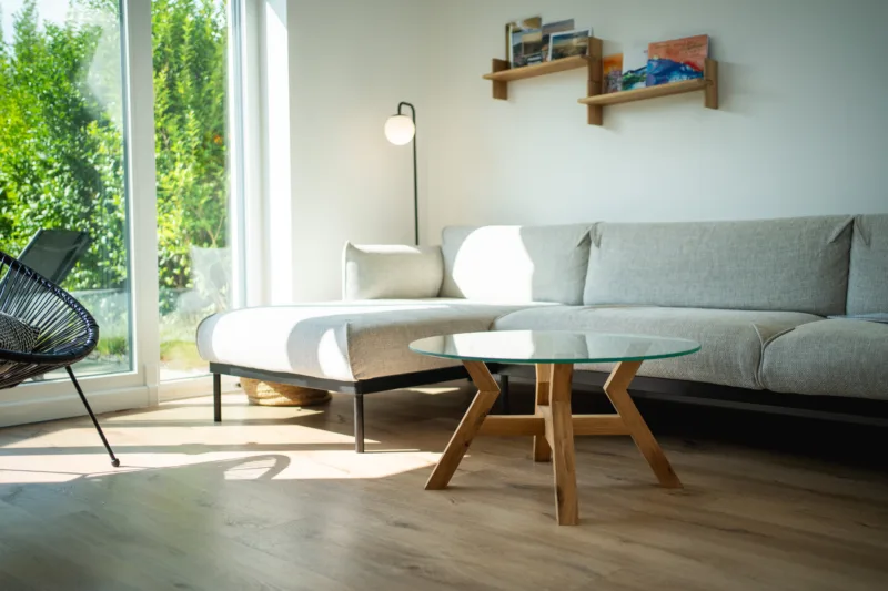 Konferenční dubový stůl Bon Veyron se skleněnou deskou Glase Cir 80 cm v interiéru pohled ze strany.