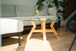 Konferenční dubový stůl Bon Veyron se skleněnou deskou Glase Cir 80 cm v interiéru pohled ze strany zblízka.