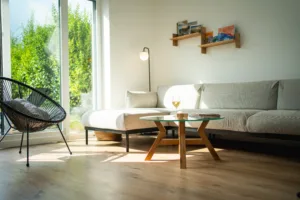 Konferenční dubový stůl Bon Veyron se skleněnou deskou Glase Cir 80 cm v interiéru pohled ze strany.