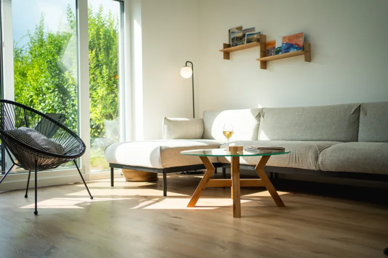 Konferenční dubový stůl Bon Veyron se skleněnou deskou Glase Cir 80 cm v interiéru pohled ze strany.