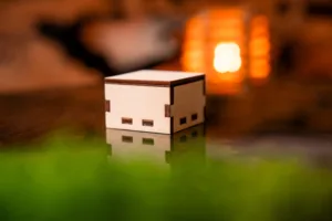 Hranatá dřevěná gravírovaná krabička na náušnice Space root zavřená v interiéru pohled ze strany.