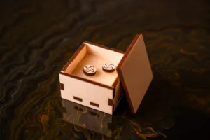 Hranatá dřevěná gravírovaná krabička na náušnice Space root otevřená v interiéru pohled shora.